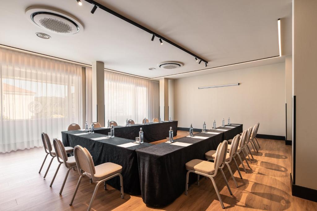 Konferenču telpa ar garu galdu un krēsliem, apgaismota ar dabiskiem gaismas avotiem un mūsdienīgu interjeru. Ideāla vieta sanāksmēm un pasākumiem.