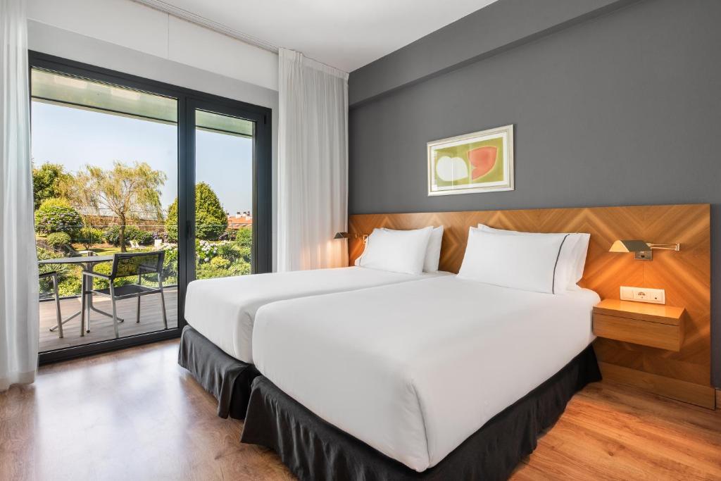 Mūsdienīgs viesnīcas numurs ar divām atsevišķām gultām un balkonu, no kura paveras skats uz zaļo dārzu. Numurā ir gaišas krāsas interjers un koka grīda.