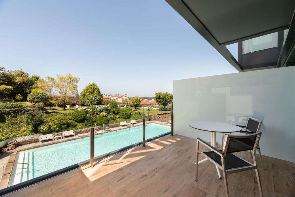 Mūsdienīga terase ar skatu uz peldbaseinu un dārzu, kurā ir zaļumi un sauļošanās krēsli. Ideāla vieta relaksācijai un atpūtai.