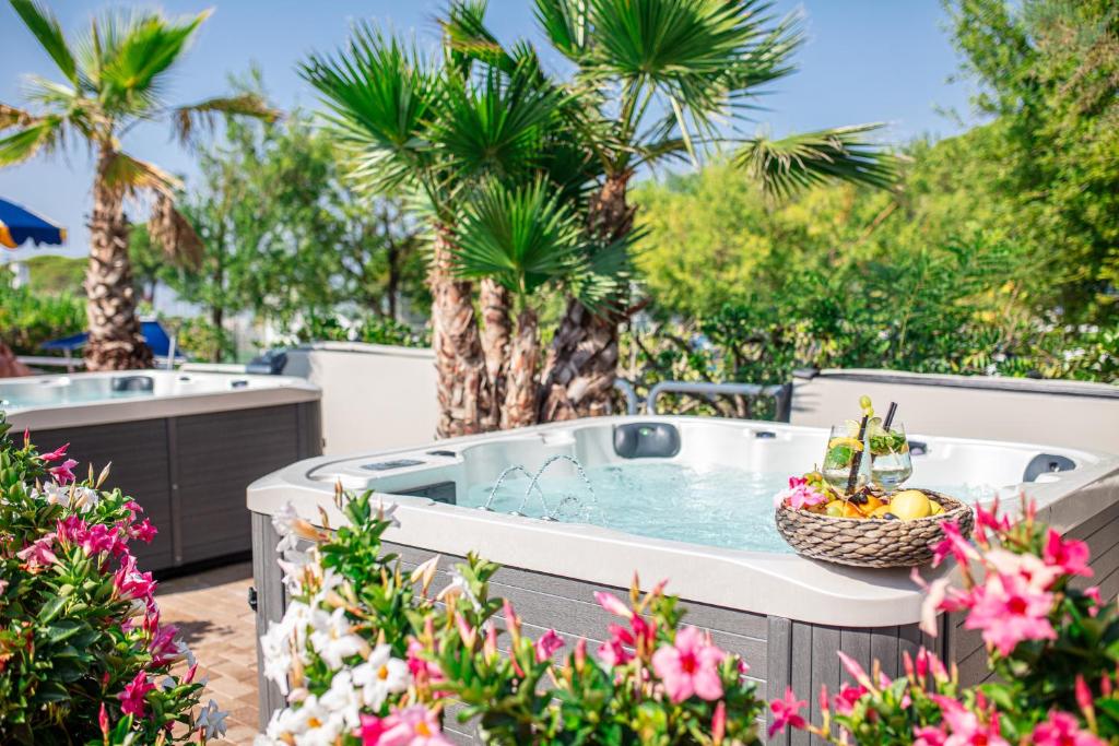 Relaksējošs āra burbuļvanna, ko ieskauj zaļumi un ziedi, ar kokteiļiem un augļiem uz galda. Ideāla vieta atpūtai un komfortam.