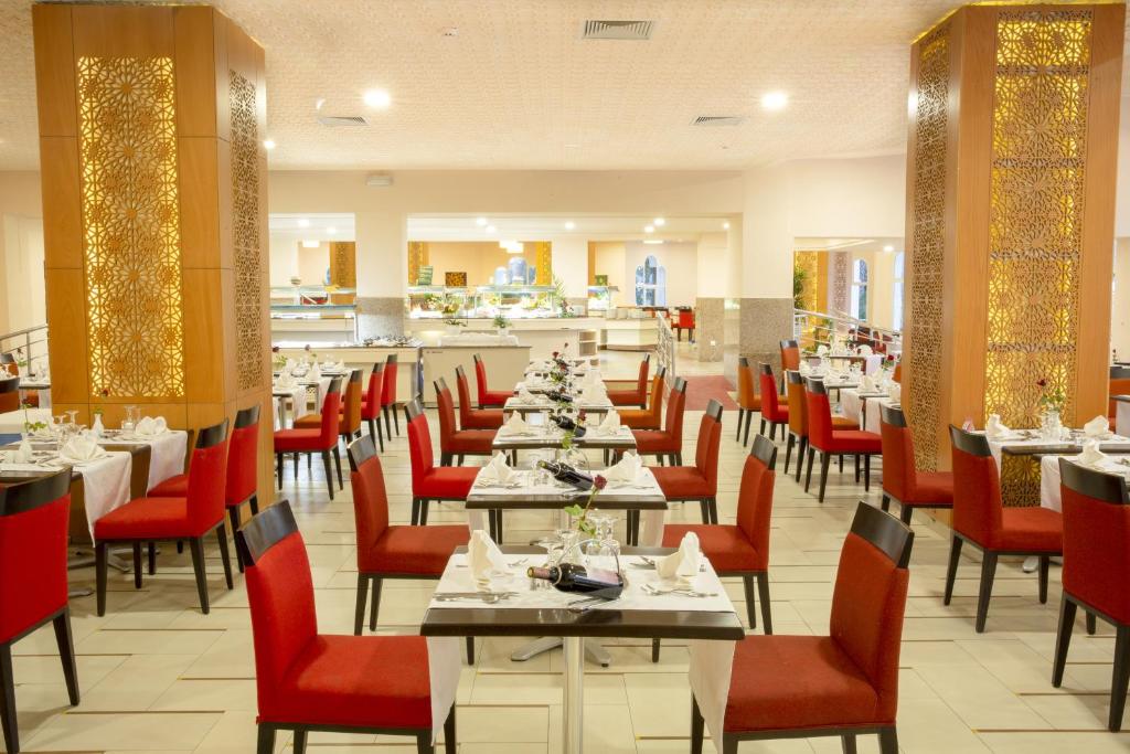 Mūsdienīgs restorāns ar elegantiem sarkaniem krēsliem un vakariņu galdiem, kas ir sagatavoti apkalpošanai. Interjers ir stilīgs un viesmīlīgs.
