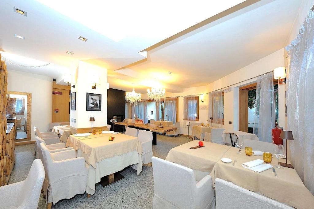 Eleganta restorāna iekārtojums ar gaišām krāsām, komfortablu mēbelējumu un izsmalcinātiem apgaismojuma elementiem. Ideāla vide romantiskām vakariņām vai svinībām.