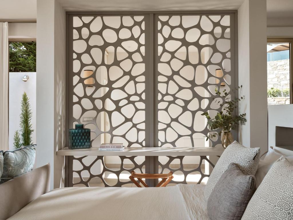 Mūsdienīgs interjers ar inovatīvu akcentu - dekoratīva starpsiena ar organiskām formām, kas atdala telpas, radot gaisīgu un stilīgu atmosfēru.