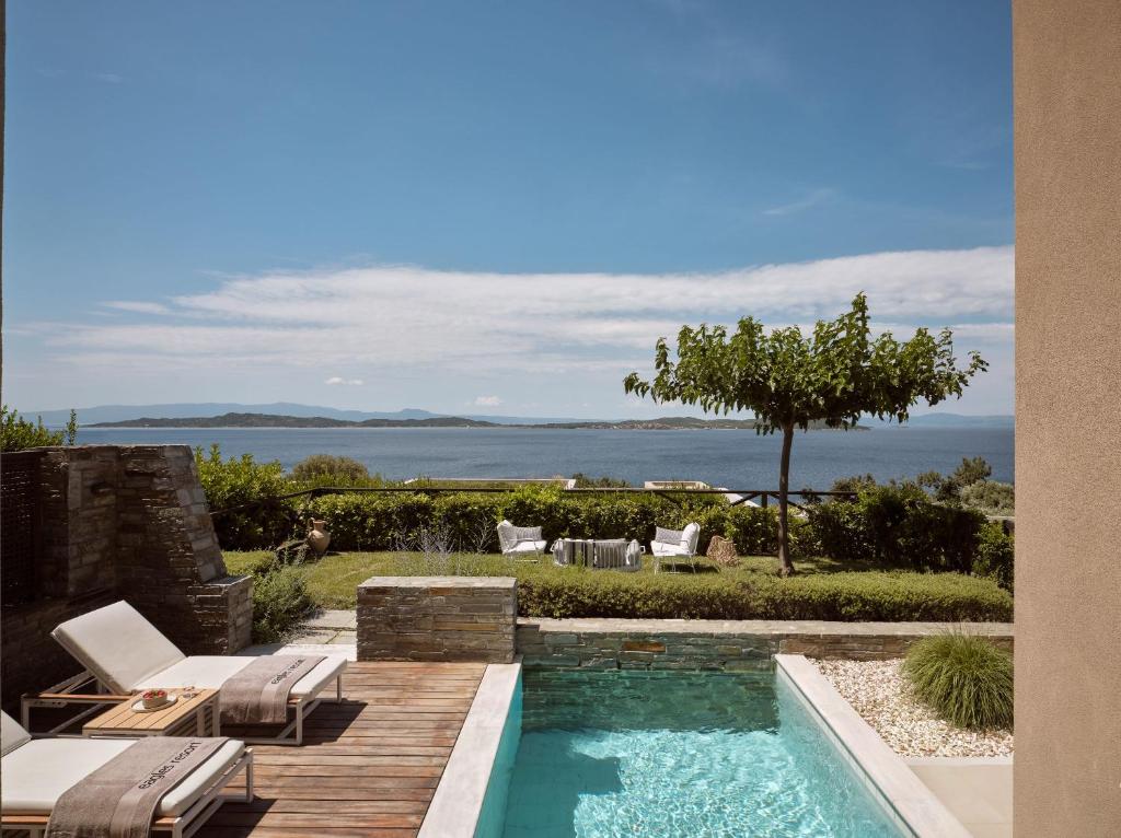 Eleganta atpūtas zona ar baseinu, kas piedāvā skatu uz jūru un zaļo ainavu. Ideāla vieta relaksācijai un mierīgai atpūtai brīvā dabā.