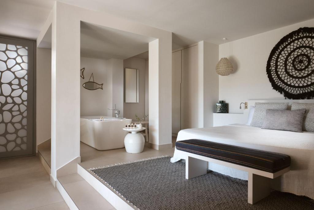 Mūsdienīgs guļamistabas interjers ar atvērta plānojuma vannas istabu, dekoratīviem elementiem un elegantu apgaismojumu. Svaigi un neitrāli toņi rada mierīgu atmosfēru.