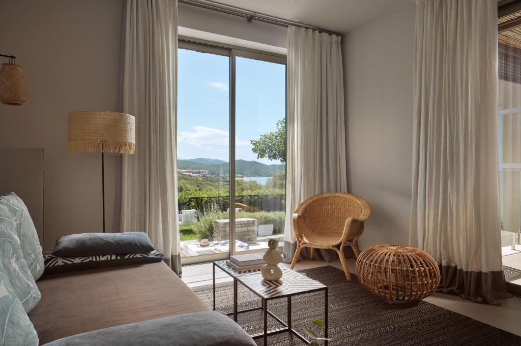 Mūsdienīga viesistaba ar skatu uz dabu, kurā ir ērti sēdēšanas elementi un lieli logi, kas ļauj ienākt dabiskai gaismai. Interjers ir veidots ar neitrālām krāsām un dabīgiem materiāliem, radot mierīgu atmosfēru.