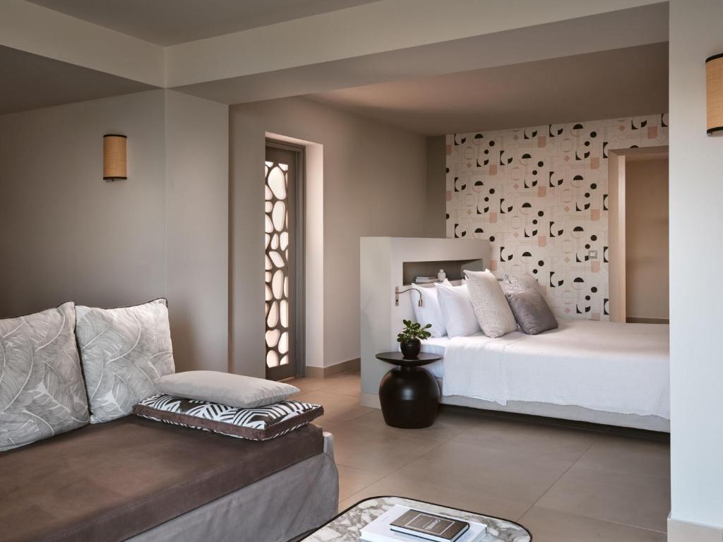 Mūsdienīgs viesnīcas numurs ar stilīgu interjeru, ietverot ērtu dīvānu un gultu ar dekoratīvām spilveniem, kā arī pievilcīgu sienas apdari. Gaismas un telpas harmonija rada relaksējošu atmosfēru.