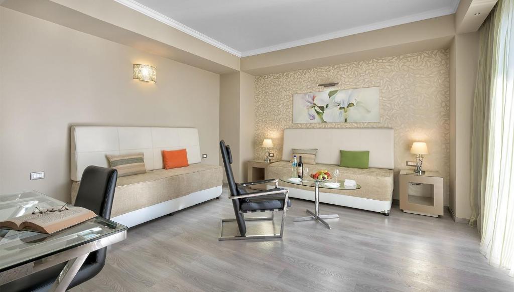 Mūsdienīga viesnīcas istaba ar gaišu interjeru, ērtu dīvānu un galdu, dekorēta ar ziedu mākslu un dabīgu apgaismojumu. Ideāla vieta atpūtai un relaksācijai.