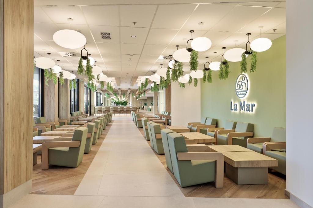 Mūsdienīgs restorāna interjers ar gaišām krāsām, koka elementiem un ziemcietēm, kas karājas no griestiem, radot patīkamu atmosfēru. Uz sienas redzams restorāna nosaukums "La Mar".
