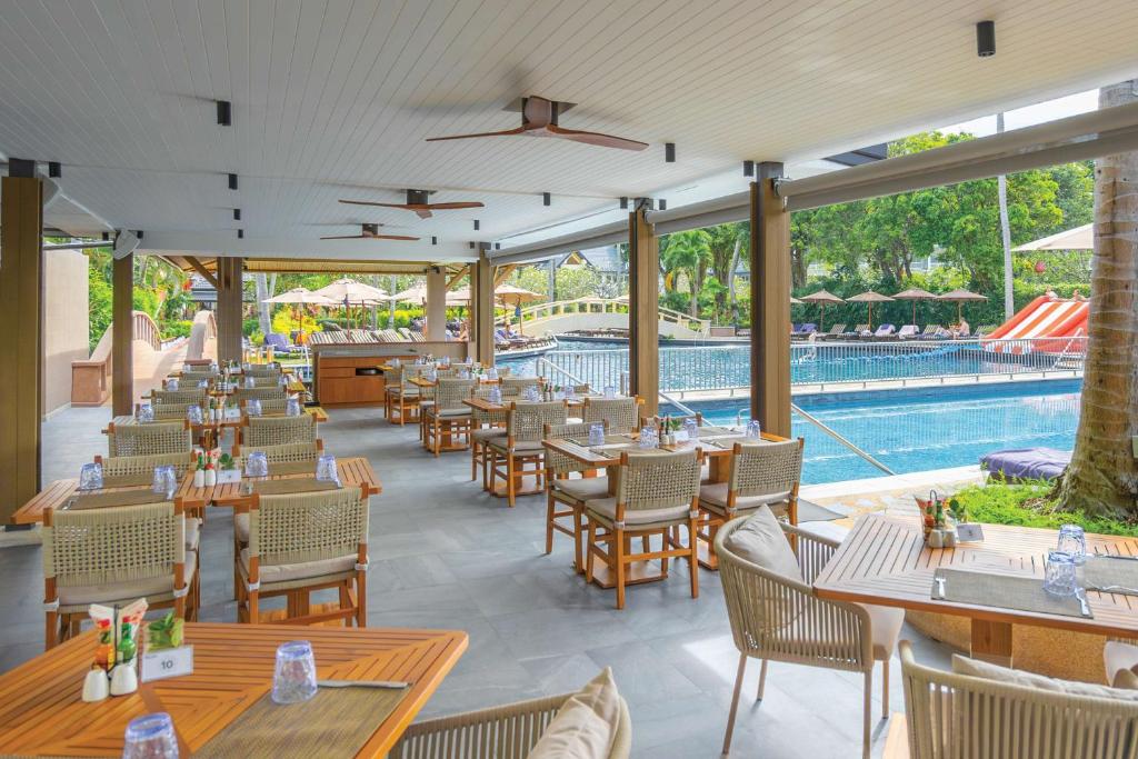 Ēdamzāle pie baseina Angsana Laguna Phuket, ar galdiem un krēsliem.