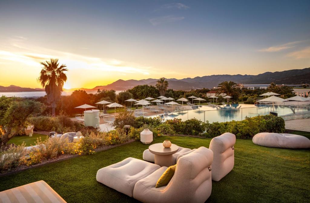 Eleganta atpūtas zona ar mīkstām mēbelēm, baseinu un palmām, kas piedāvā elpu aizraujošu saulrietu skatu kalnu fona. Ideāla vieta relaksācijai un mierīgai atmosfērai.