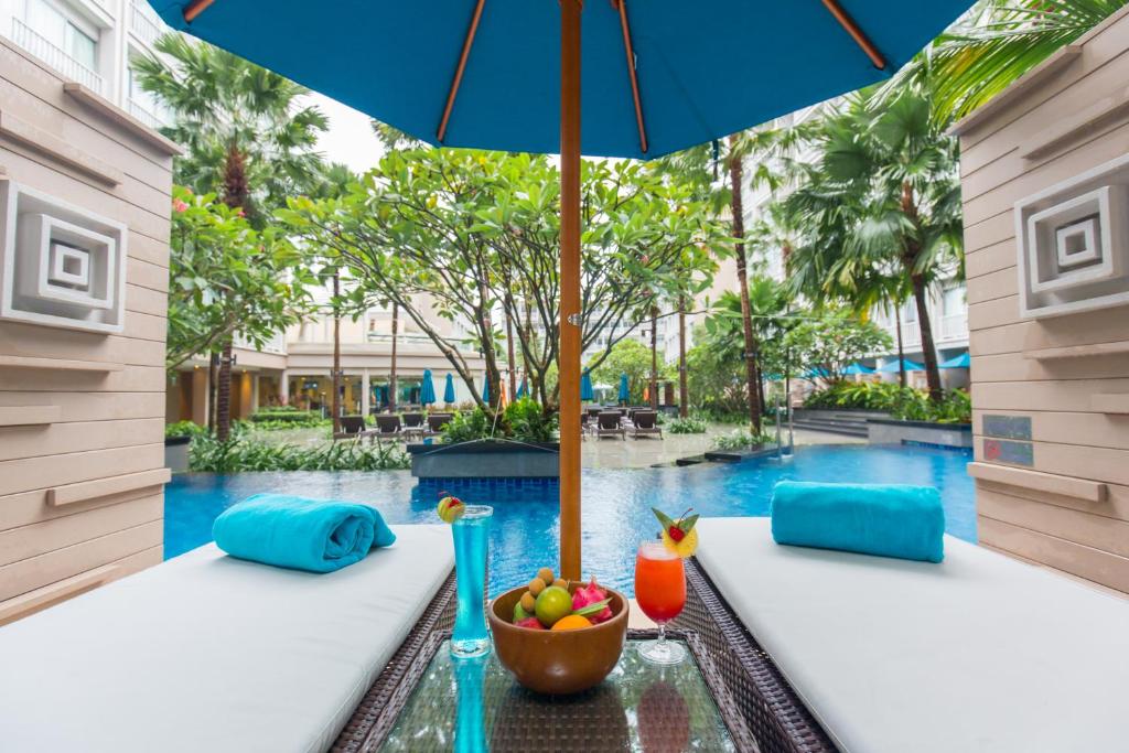Relaksējoša atpūta pie baseina Grand Mercure Phuket Patong, ar dzērieniem un augļiem.