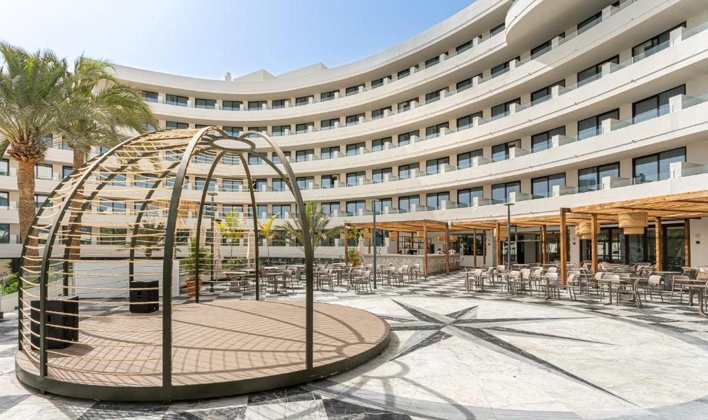 Mūsdienīgs viesnīcas iekšpagalms ar elegantu dizainu, dekorēts ar palmām un atpūtas zonām. Centrā ir koka konstrukcija, kas piedāvā patīkamu atmosfēru.