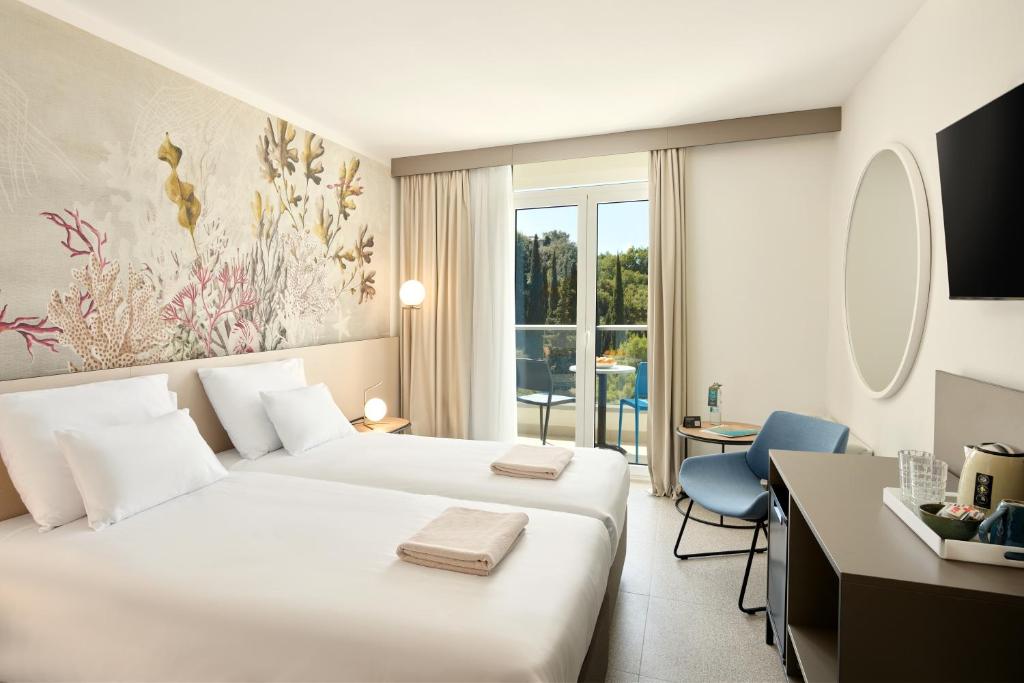 Mūsdienīgs viesnīcas numurs ar divām gultām, dekorēts ar jūras augu motīviem uz sienas, ar balkonu un dabīgu apgaismojumu. Numurā ir ērta atpūtas zona un moderni mēbeles.