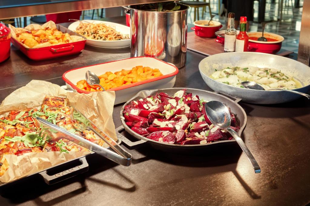 Svaigas un krāsainas uzkodas, tostarp cepti kartupeļi, burkāni un bietes, pasniegtas dažādās traukos. Ideāli piemērots bufetes stilam.