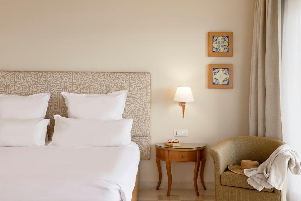 Mūsdienīgs viesnīcas numurs ar ērtu gultu, dekoratīvām spilveniem un mājīgu sēžamo stūri. Interjerā ir gaišas krāsas un mākslas darbi uz sienām, radot relaksējošu atmosfēru.