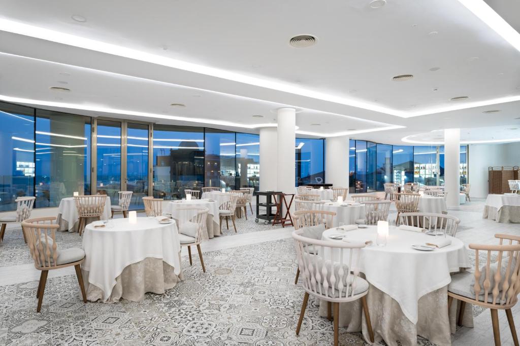 Mūsdienīgs restorāns ar elegantiem galdiem un krēsliem, plašām logu daļām, kas nodrošina lielisku skatu un dabiska apgaismojuma ietekmi. Interjers apvieno modernu dizainu ar komfortu.