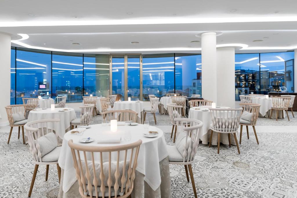 Mūsdienīgs restorāns ar elegantiem galdiem un krēsliem, panorāmas logiem, kas paver skatu uz pilsētu. Interjers ir gaišs un viesmīlīgs, radot patīkamu atmosfēru.
