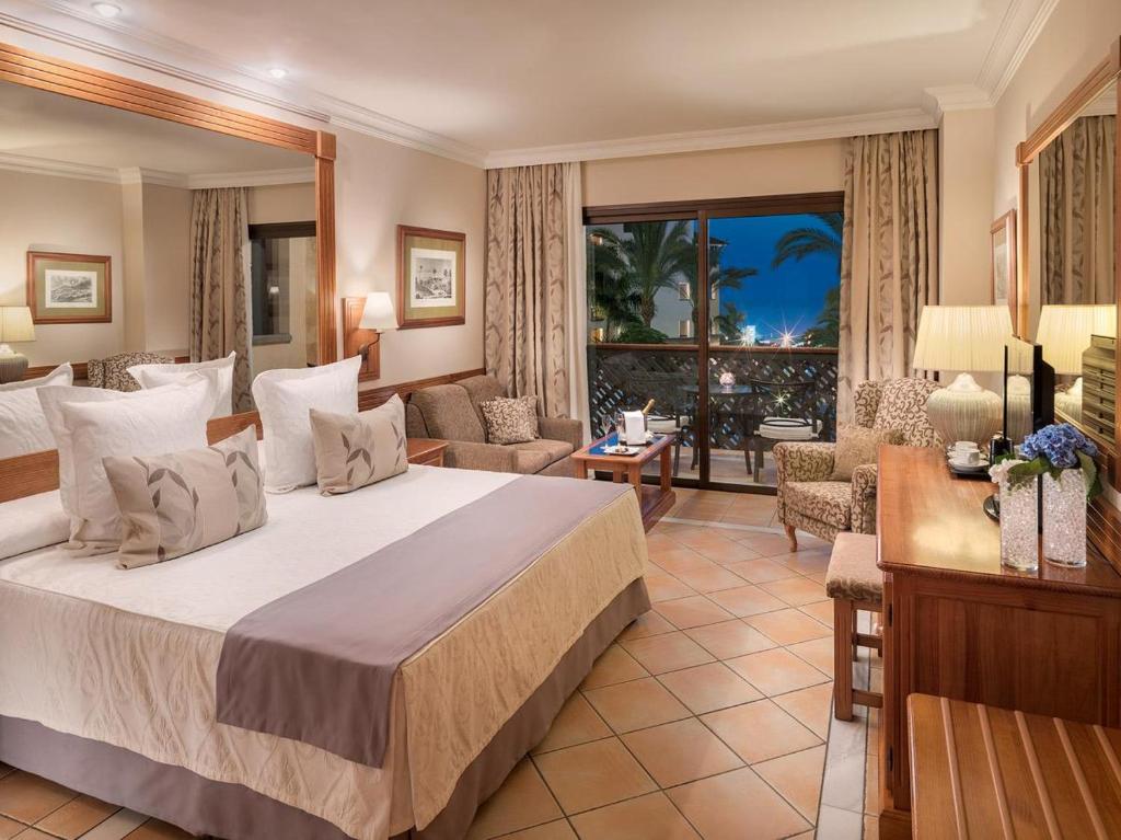 Elegants viesnīcas numurs ar divguļamo gultu, ērtu atpūtas zonu un skatu uz dārzu. Interjers ir gaišs un mājīgs, radot patīkamu atmosfēru.