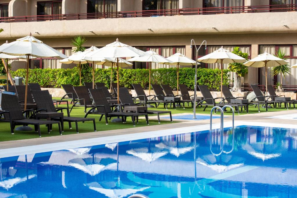 Lieliska peldbaseina ar saulessargiem un atpūtas krēslim, kas izvietoti pie viesnīcas, radot relaksējošu atmosfēru. Ideāla vieta atpūtai un izklaidei.