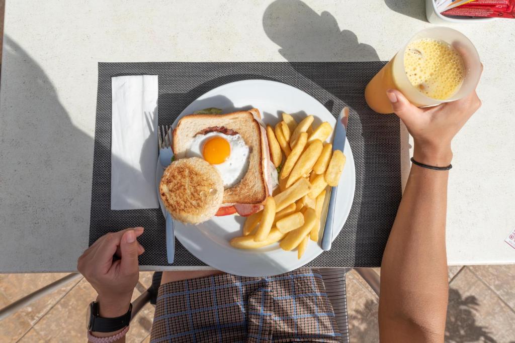 Broka ar ceptu olu uz maizes šķēles, kartupeļu frī un augļu sulu. Ideāls sākums dienai, baudot garšīgu maltīti.