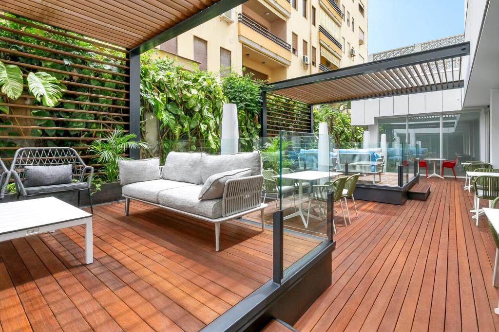 Moderns terases dizains ar ērtām mēbelēm un zaļumiem, kas rada relaksējošu atmosfēru. Koka grīda un stikla barjeras piešķir eleganci un svaigumu.