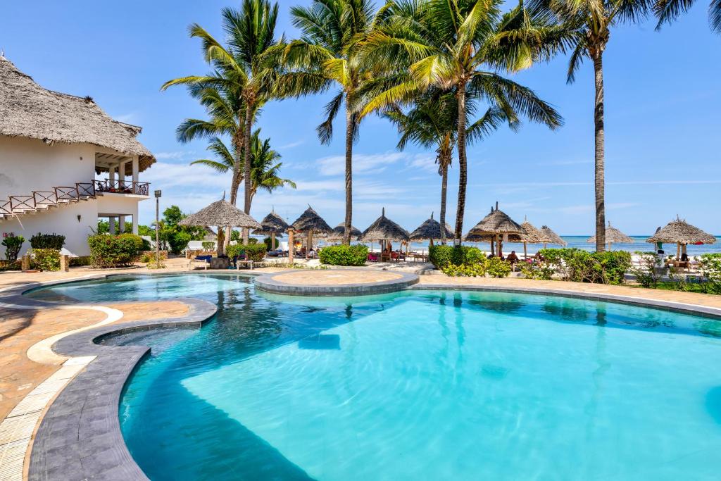 AHG Waridi Beach Resort & Spa baseins ar palmām un sauli piekrastē