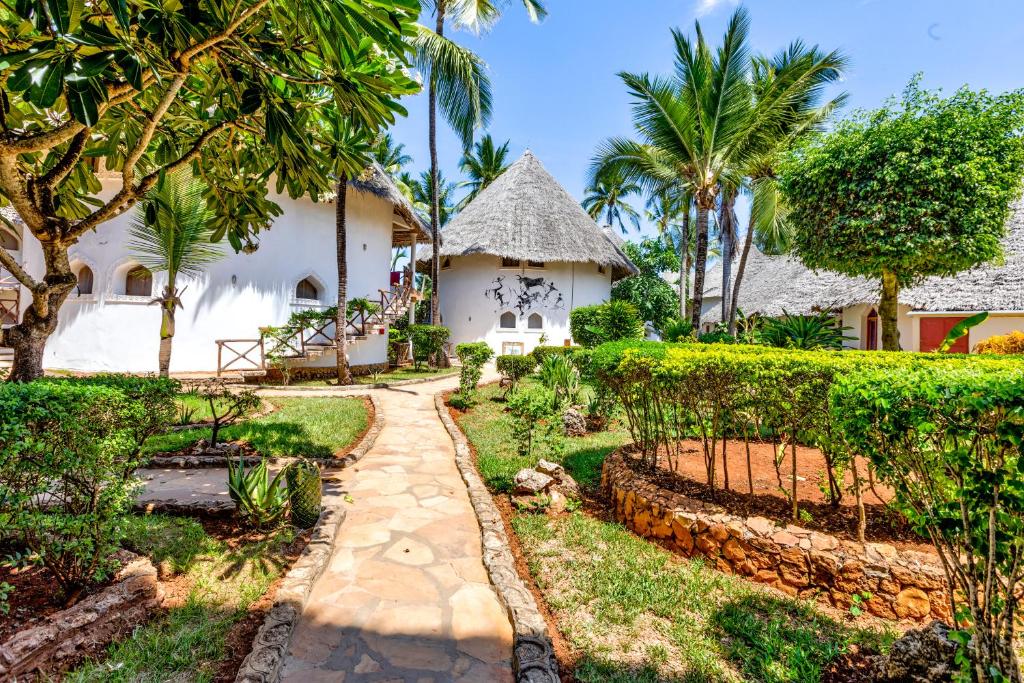 AHG Waridi Beach Resort & Spa dārza ceļš ar baltiem numuriem un palmu kokiem