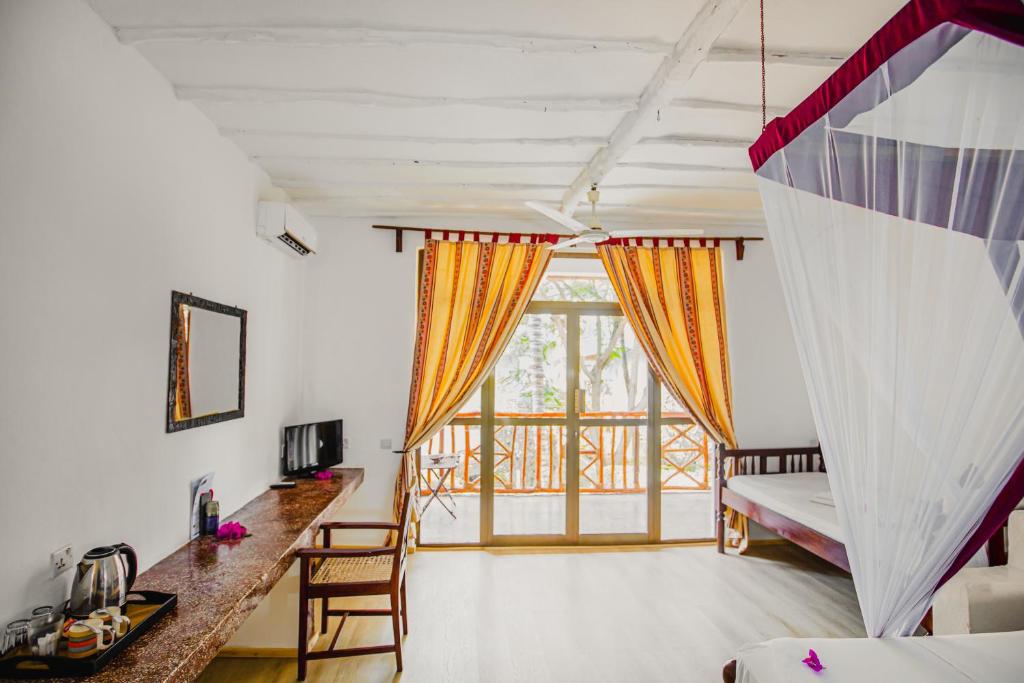 Gaišs un plašs numurs AHG Waridi Beach Resort & Spa ar balkonu un modernu dizainu.