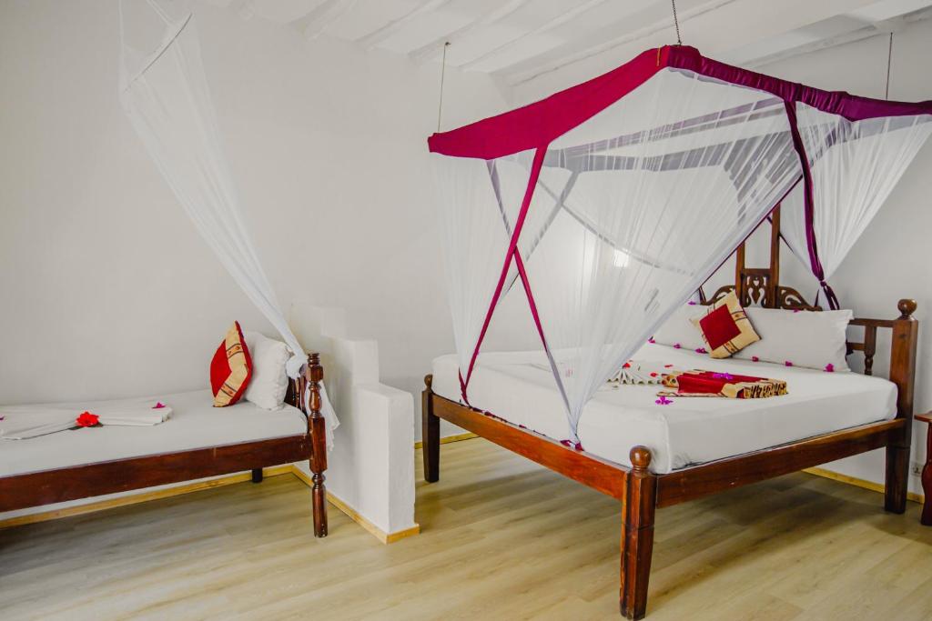 Elegant numuri AHG Waridi Beach Resort & Spa ar gultu un moskītu tīklu