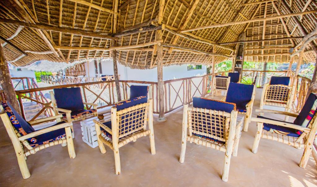 Bamboo un koka mēbeles atpūtas telpā ar jumtu, kas izveidota tradicionālā stilā. Telpa ir gaiša un atklāta, nodrošinot komfortablu vidi.