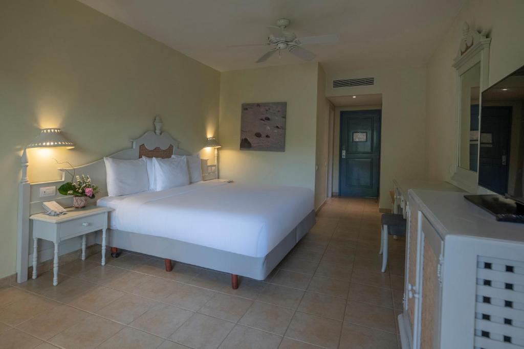 Mūsdienīgs viesnīcas numurs ar plašu gultu, gaismas lampām un vienkāršu interjeru. Sienas ir izkrāsotas gaišās krāsās, radot relaksējošu atmosfēru.