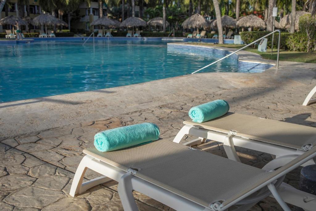 Peldbaseins ar divām sauļošanās krēslām un tirkīza dvieļiem, apkārt augstiem palmu kokiem un paviljoniem. Ideāla vieta relaksācijai un atpūtai.