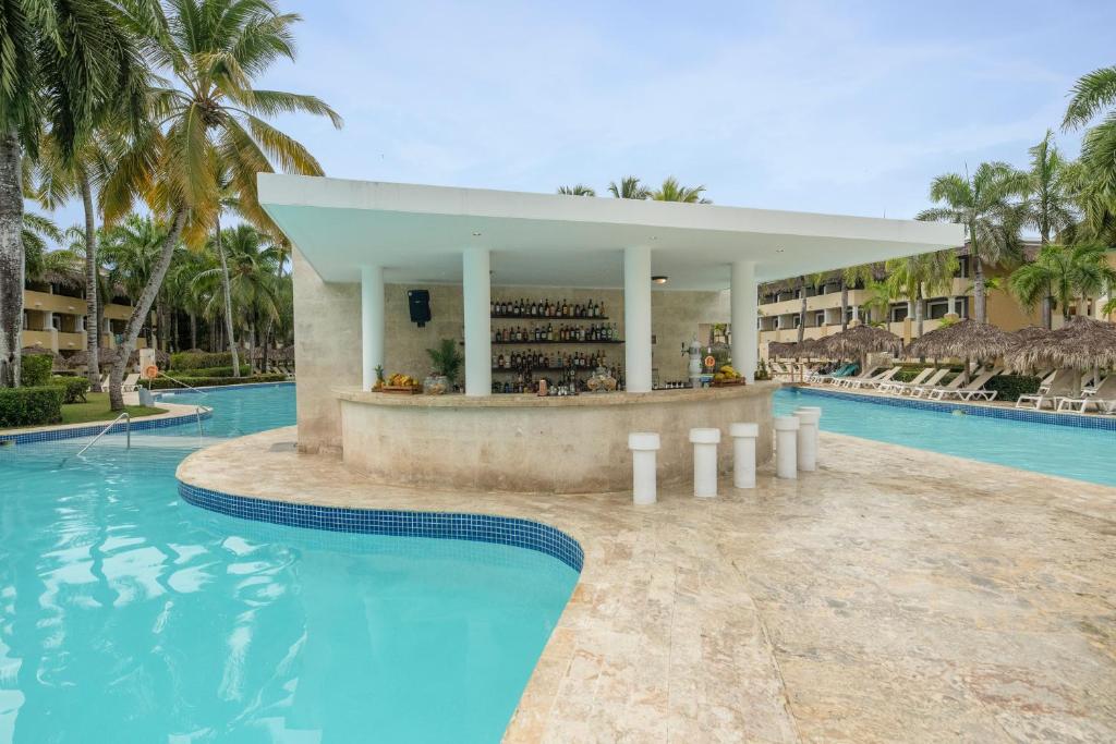 Baseins ar bāru, kas ieskauts palmām un viesnīcu kompleksu, piedāvā relaksējošu atmosfēru. Šis tropiskais ainava ir ideāla vieta atpūtai un izklaidei.