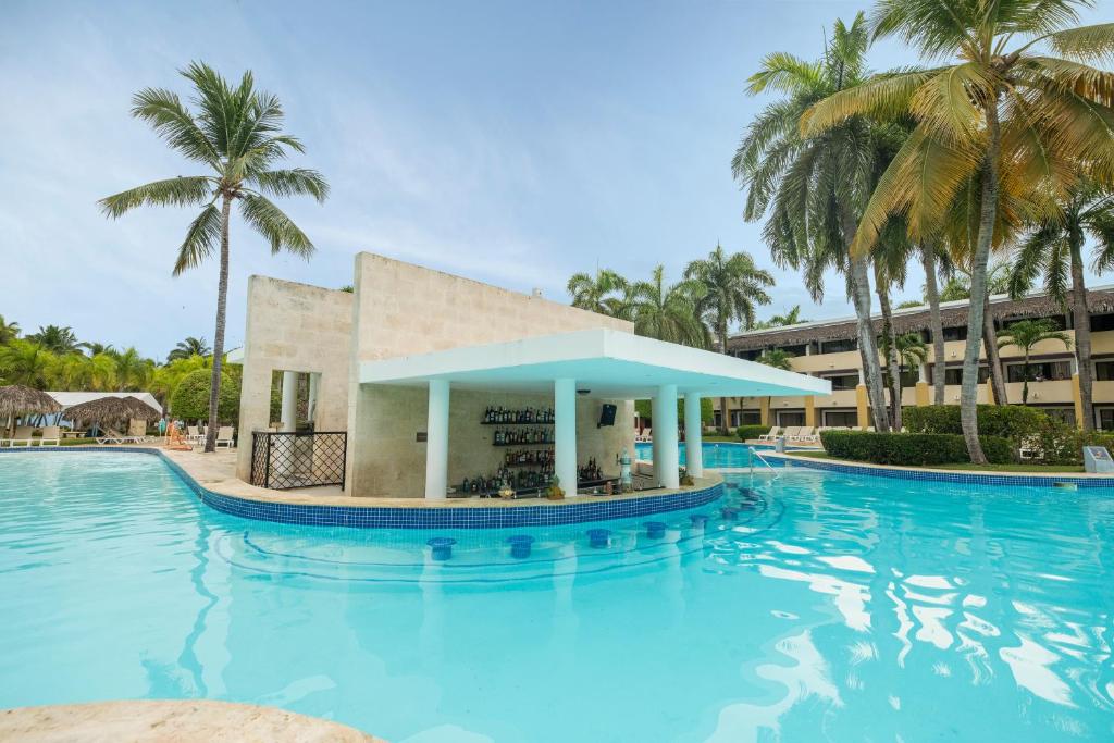 Peldbaseins ar bāru, ko ieskauj palmas un viesnīcas ēka. Lieliska tropu atmosfēra un relaksējoša vide.