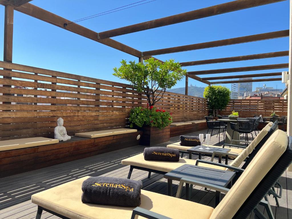 Relaksējoša terase ar sauļošanās krēsliem, dārza augiem un budas statuju, ideāla vieta atpūtai. Saule spīd, un skats uz pilsētu ir brīnišķīgs.