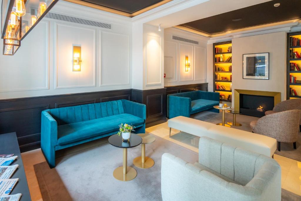 Mūsdienīgs viesnīcas vestibils ar elegantiem mēbeļu komplektiem, ieskaitot zilo dīvānu un krēslus. Siltas krāsas un mūsdienīga apgaismojuma elementi rada komfortablu atmosfēru.