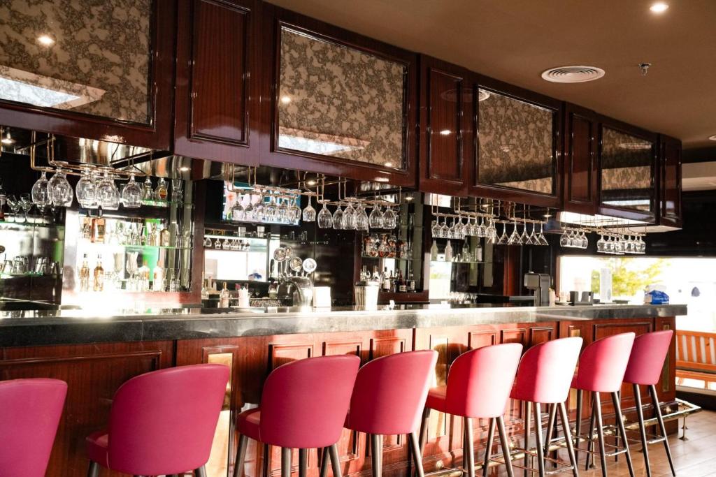 Bārs ar rozā krēslām un glāzēm Sentido Reef Oasis Senses Resort