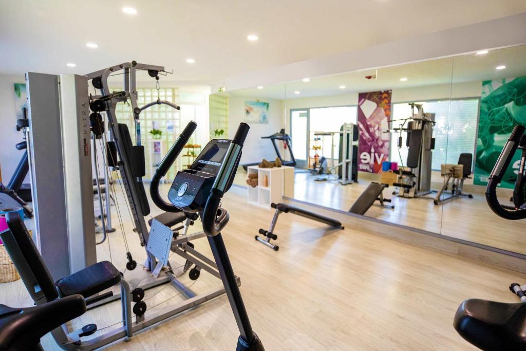 Mūsdienīgs sporta zāles interjers ar dažādām treniņu iekārtām un spoguļiem, kas rada plašuma sajūtu. Ideāla vide fiziskajām aktivitātēm un veselīgam dzīvesveidam.