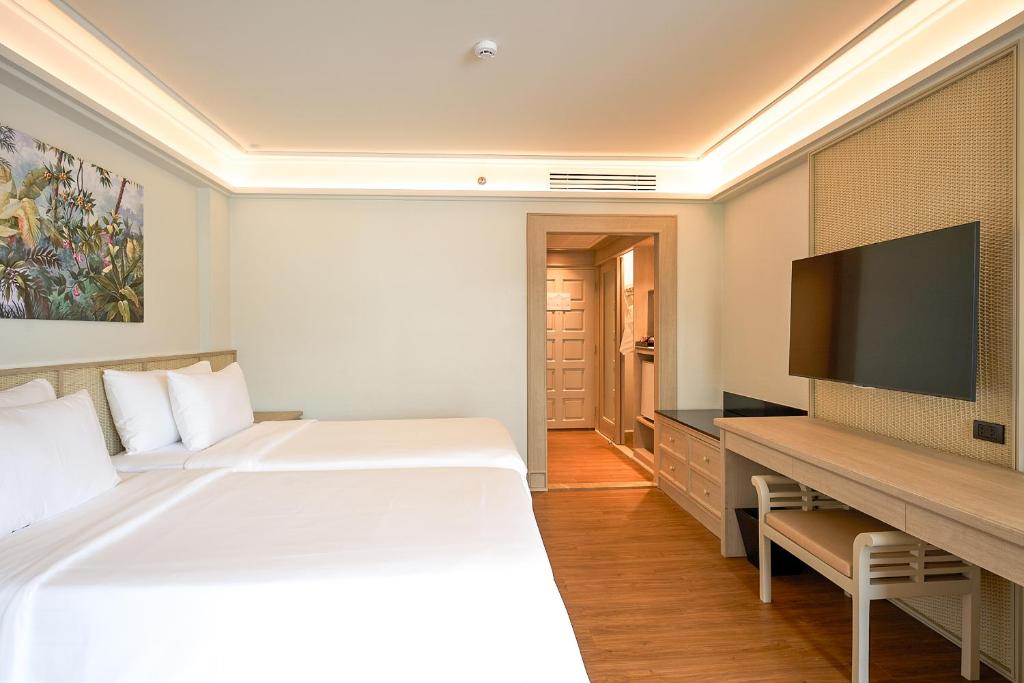 Mūsdienīga viesnīcas istaba ar divām gultām, televizoru un rakstāmo, kā arī skaistu ainavu gleznu uz sienas. Interjers ir gaišs un elegants, radot komfortablu atmosfēru.