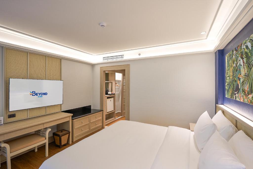 Moderns viesnīcas numurs ar plakātu, televizoru un elegantu apgaismojumu, kas rada patīkamu atmosfēru. Numurā ir arī koka mēbeles un dekoratīvs attēls uz sienas.