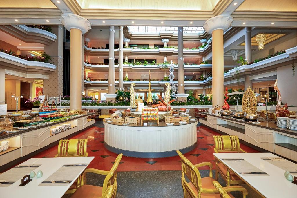 Lieliska restorāna iekšiene ar plašu bufeti, kas piedāvā dažādas gardēžu uzkodas un dzērienus, kā arī greznu interjeru ar augstiem griestiem un zaļām augiem.