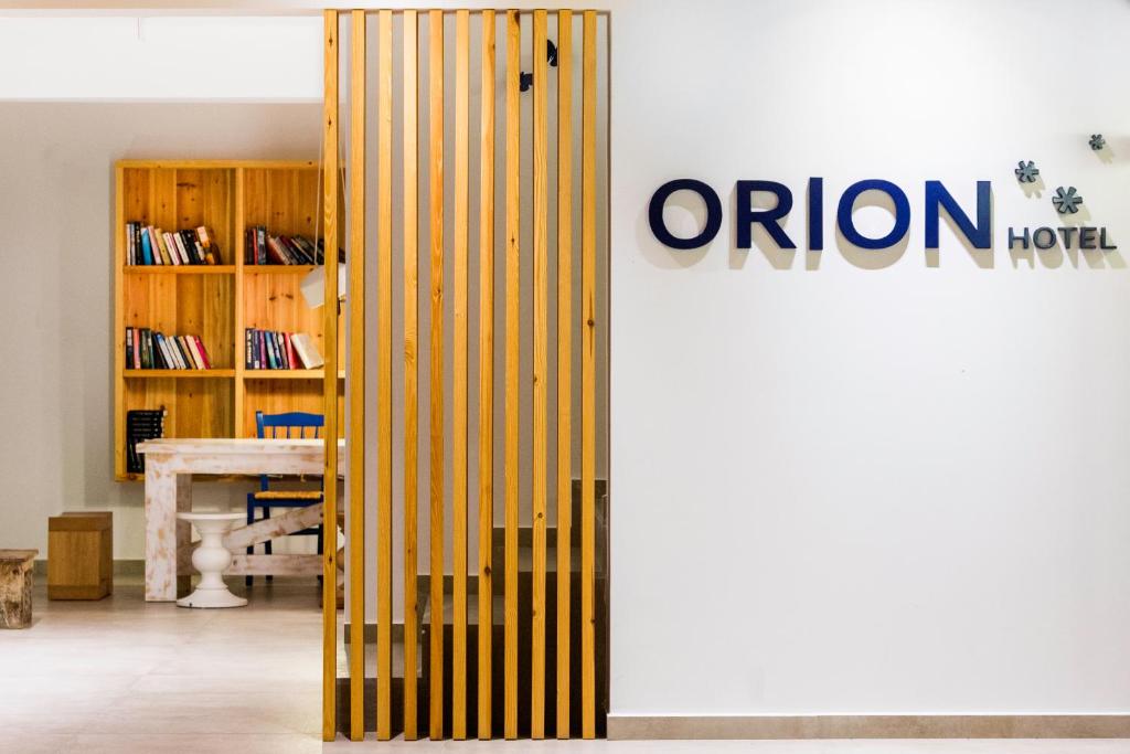 Mūsdienīgs viesnīcas "ORION" interjers ar koka grilu, grāmatplauktu un darba galdu.