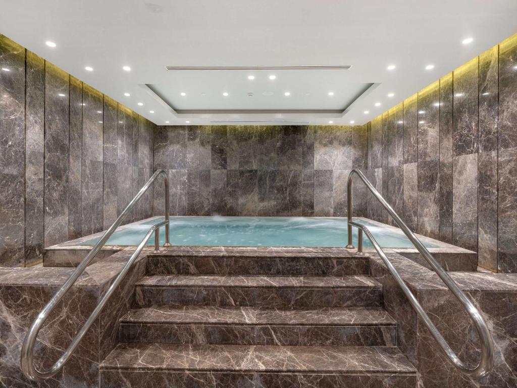 Luksusa spa zona ar marmora sienām un baseinu, kas aicina uz relaksāciju. Ideāla vide atpūtai un atjaunotnei.