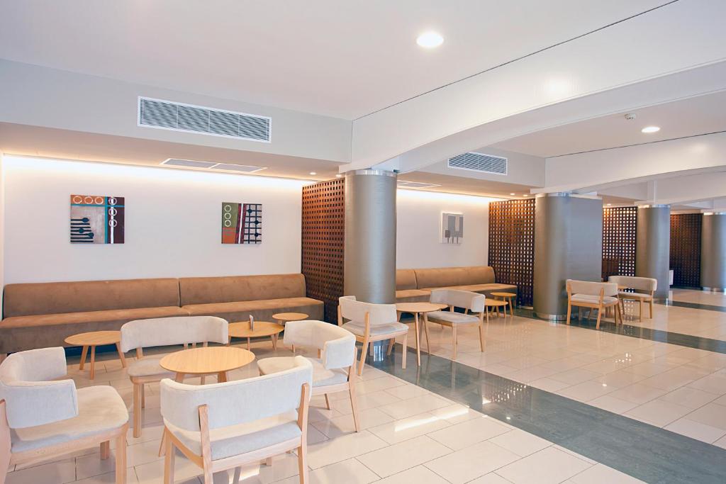 Mūsdienīgs viesnīcas vestibils ar ērtām mēbelēm un mākslas darbiem uz sienām, kas rada relaksējošu atmosfēru. Gaismas un telpas plūsma veido patīkamu vidi atpūtai.