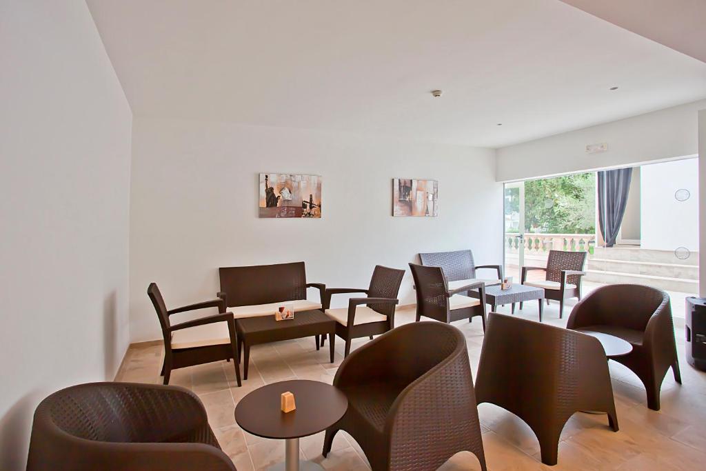 Mūsdienīgs un ērts viesnīcas atpūtas stūris ar brūniem ratanveida krēsliem un galdiņu, gaišu sienu un lieliem logiem, kas sniedz dabisku apgaismojumu.