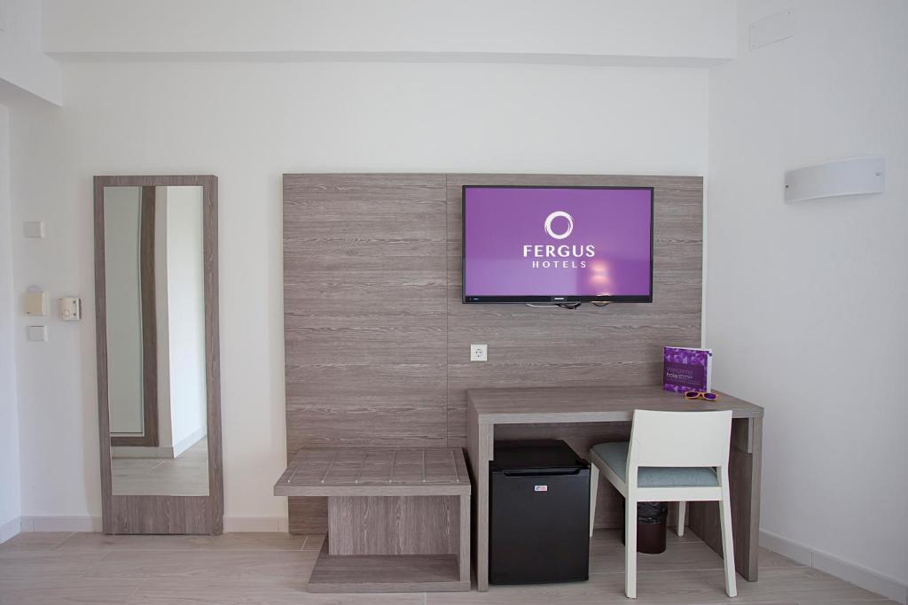 Mūsdienīgs viesnīcas numurs ar koka apdari, televizoru un rakstāmgaldu. Sienā iebūvēts spogulis un ledusskapis zem galda.