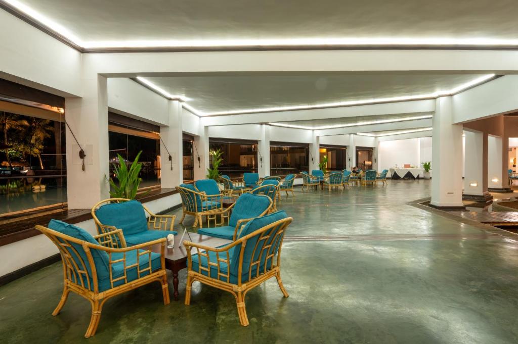 Mūsdienīgs un plašs atpūtas telpa ar rattan krēsliem un zilu apdari, kas piedāvā skatu uz baseinu. Telpa ir apgaismota ar modernām gaismām, radot relaksējošu atmosfēru.