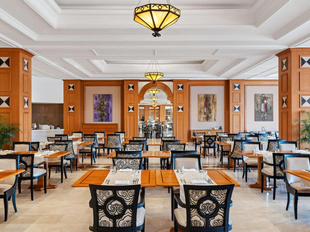 Elegantā restorāna interjers ar koka un melnbalto mēbeļu kombināciju, kas radījis viesmīlīgu atmosfēru. Gaismas ķermeņi piešķir telpai siltumu un stilu.