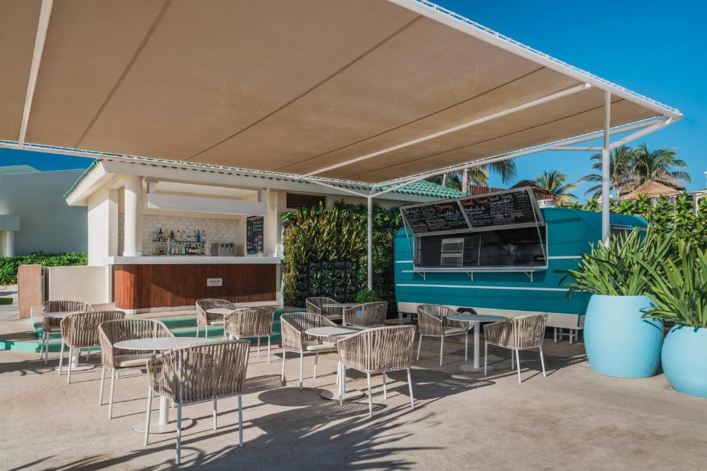 Atvērtā bāra zona ar ērtām krēslām un galdiem, zem saules aizsargājoša jumta, apzaļumota ar palmu kokiem. Bārs piedāvā dzērienus, un blakus atrodas pārtikas piegādes vagoniņš.
